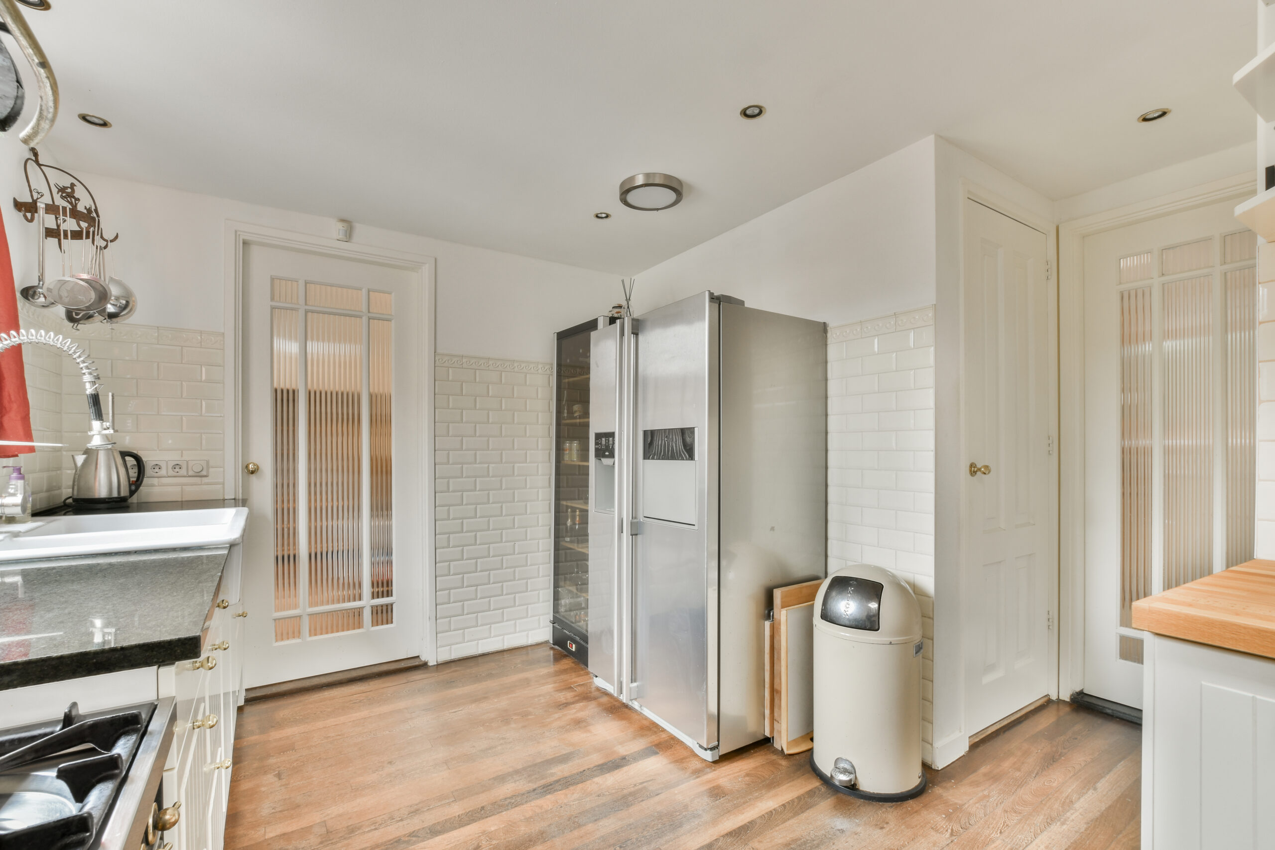 a kitchen with a stainless steel refrigerator and a sink